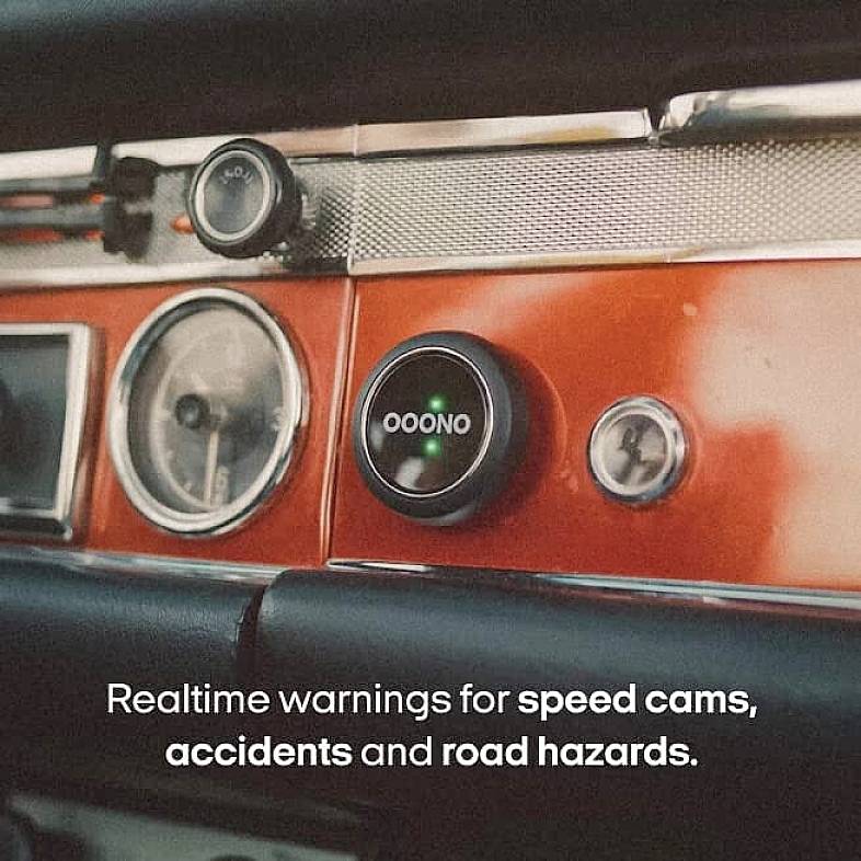 A car dashboard with a device displaying current warnings for speed cameras, accidents, and road obstacles.