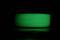 A reel of luminous, green filament on a dark background.