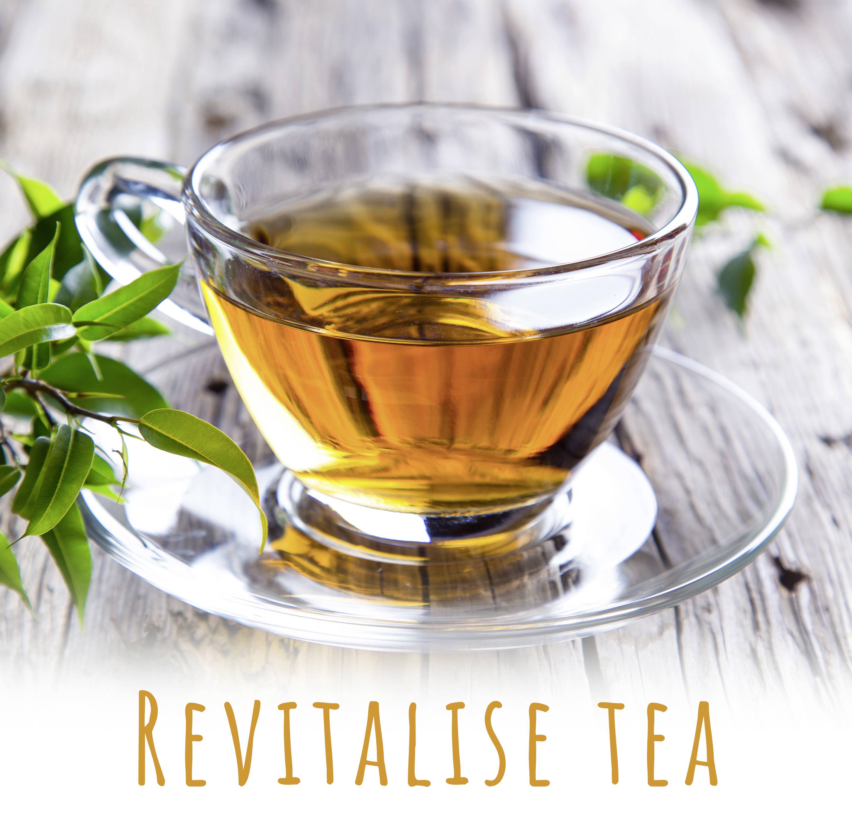 A glass cup with light tea sits on a wooden table, beside fresh tea leaves. Text underneath: 'Revitalise tea'.<br><br>Note: I used the British spelling of "revitalise" with an "s" instead of the American "revitalize" with a "z".