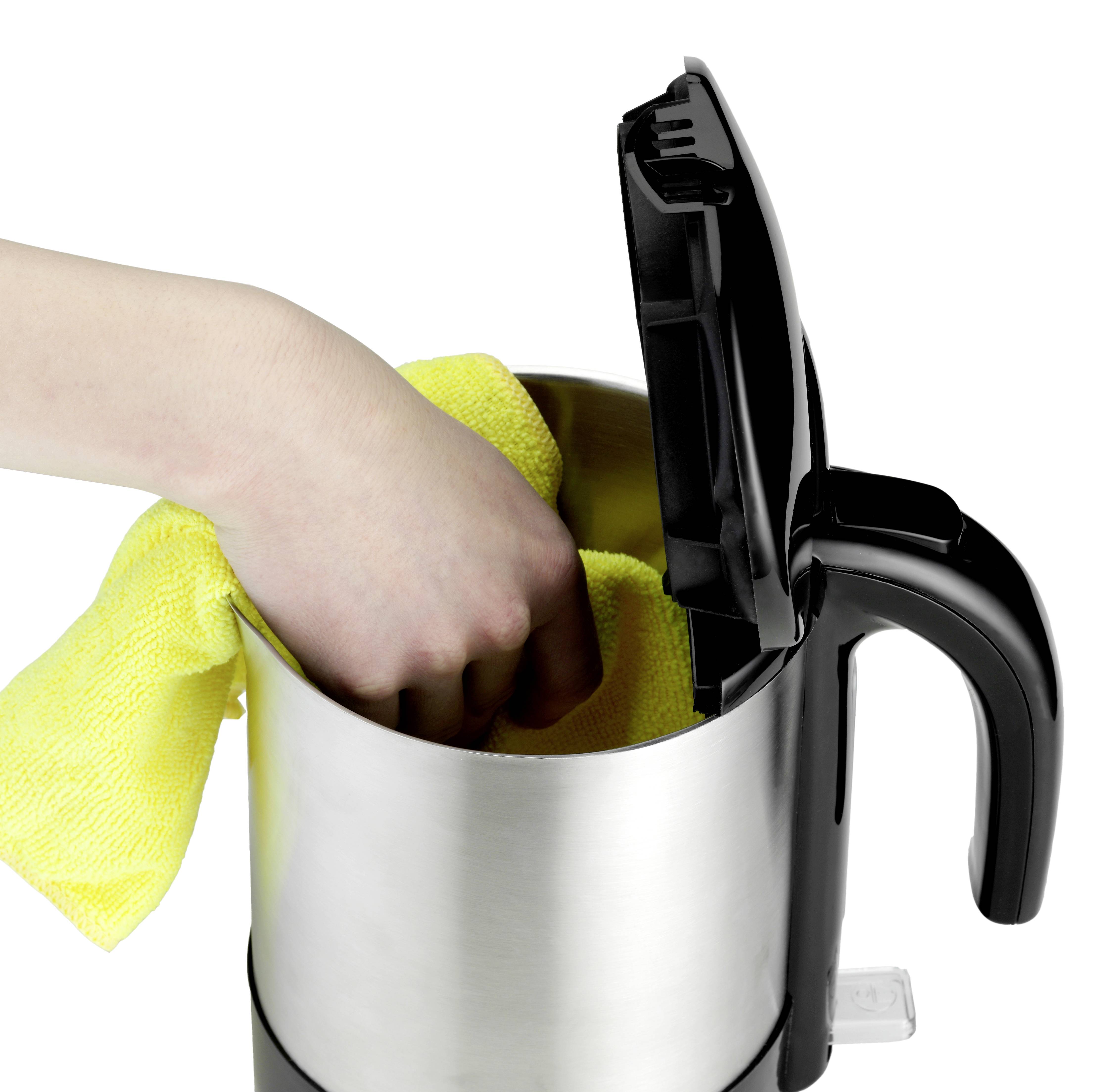 A hand is cleaning the interior of an electric kettle with a yellow cleaning cloth. The lid is open.