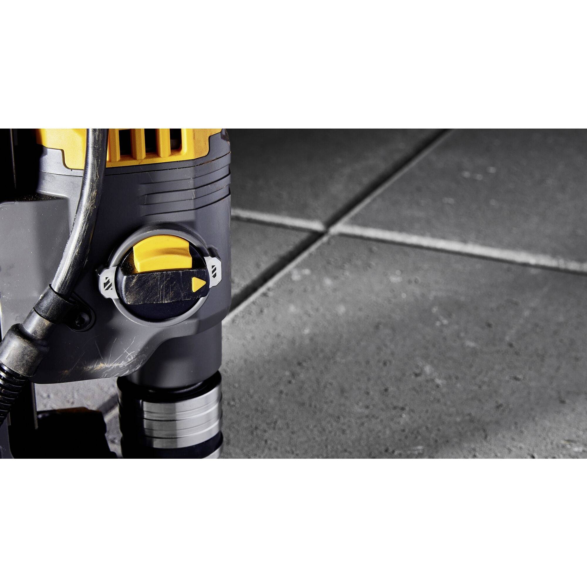 Close-up of a yellow submersible pump on grey tiles; the rotary switch is set to 'Auto'.