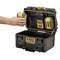 A hand places a battery into an open charger of a DEWALT ToughSystem 2.0. The system is portable and robust.