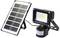 Solar panel and LED floodlight with motion sensor on white background. Suitable for energy-efficient outdoor lighting.
