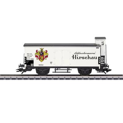 A model of a goods wagon from the 'Schlossbrauerei Hirschau' with a coat of arms, stands on railway tracks. White wagon, detailed design.