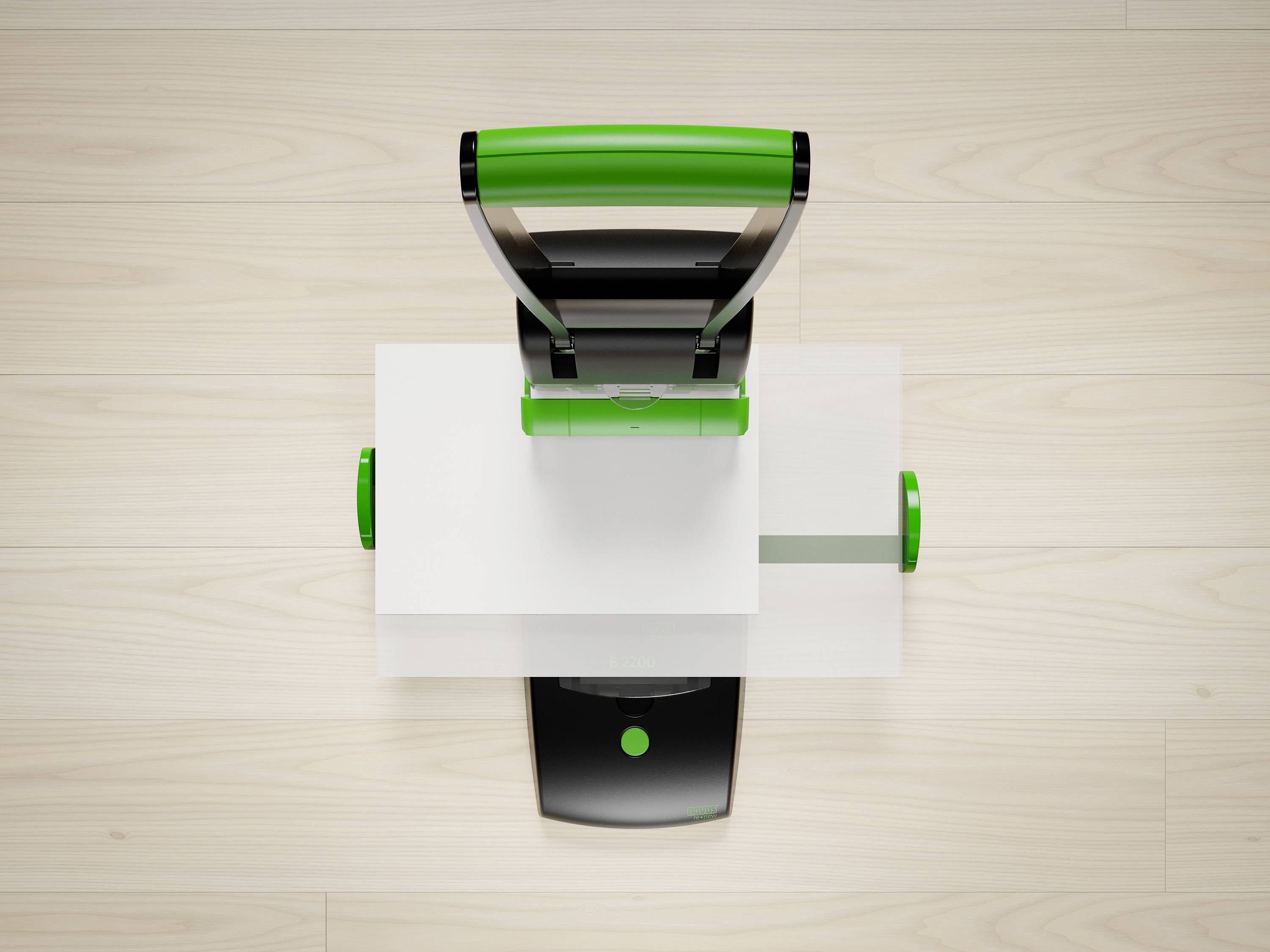 A carpet cleaner with a black and green handle stands on light wooden flooring. The view is from above, with details of the device visible.