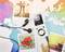 A portable music player and headphones are placed on a colourful world map background. Polaroid photos with various motifs are positioned beside them.