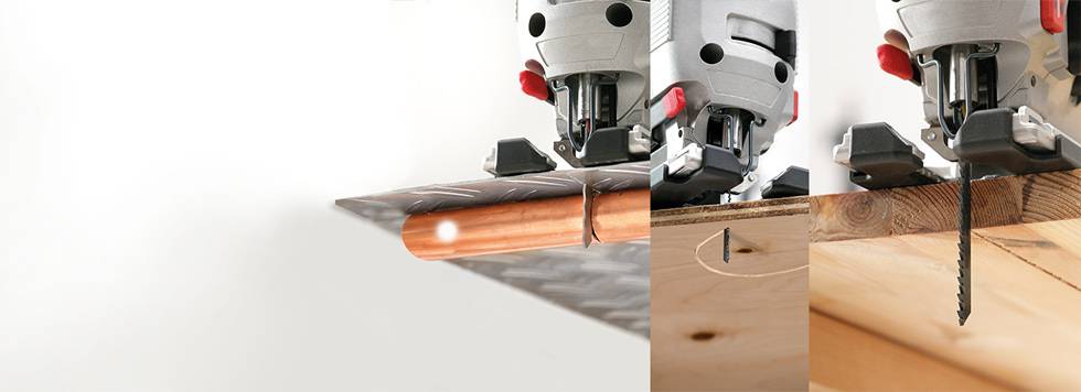 Two jigsaw saws are cutting through a wooden board simultaneously. On the left, the saw is cutting through thinner material, on the right through thicker wood.