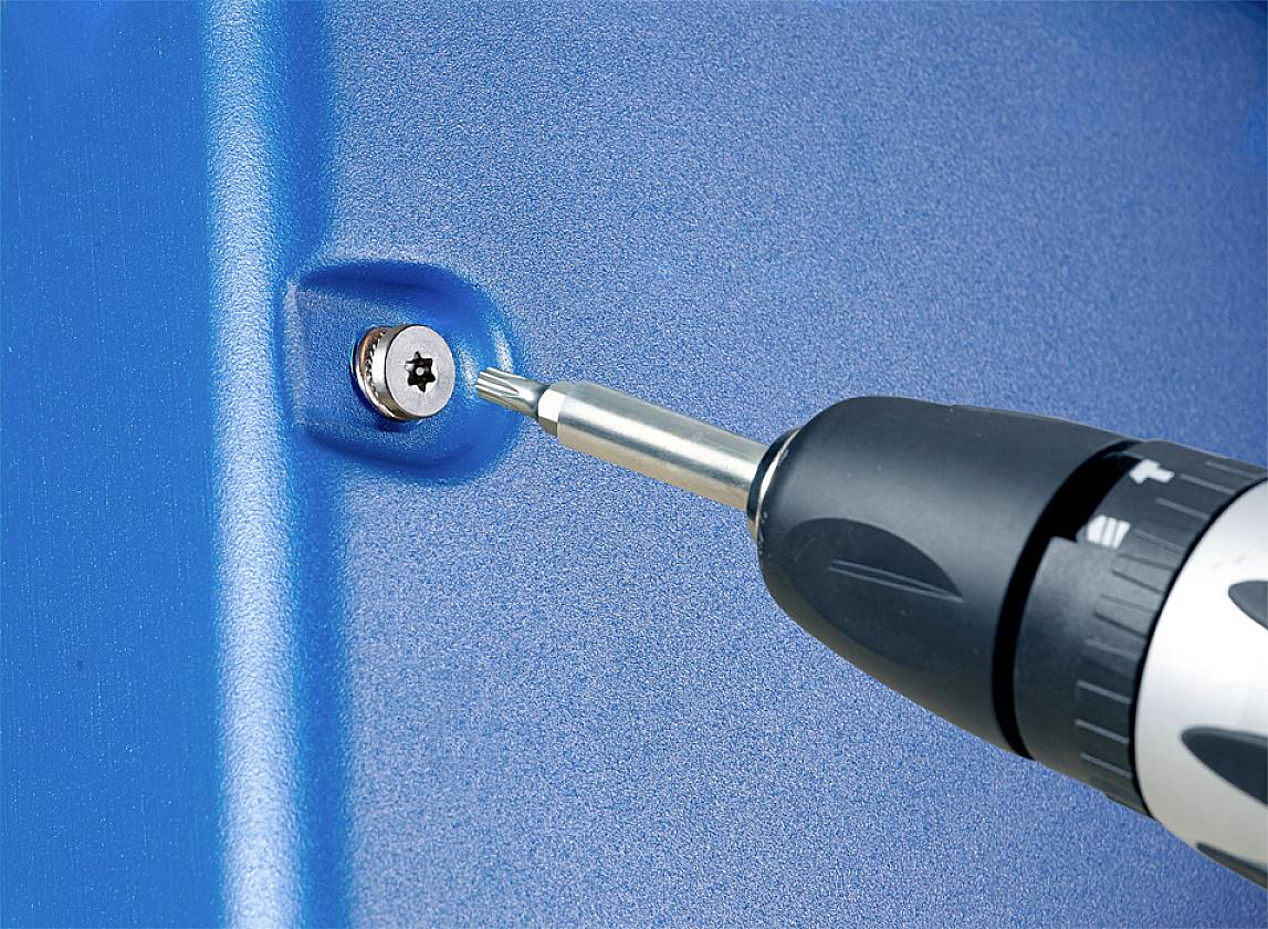 Cordless drill driving a screw into blue metal.