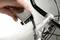 A hand tightens a screw on a bicycle handlebar using a key-shaped tool. Part of the handlebar is visible.