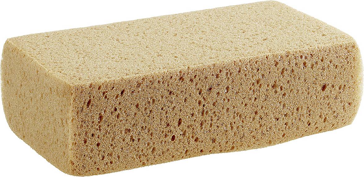 A rectangular, beige sponge with a uniform porous structure, lies on a white surface.