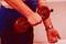 A person is holding two round devices with handles in their hands. The focus is on the person's arms and hands.
