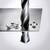 A drill pierces a metal sheet, surrounded by metal shavings.