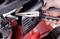 A hand is holding pliers and working on a spring in a device, possibly for maintenance or repair.