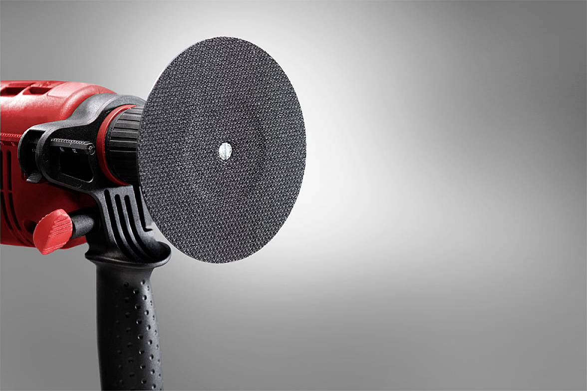A red angle grinder with a black grinding disc. The background is grey and unobtrusive, which helps to highlight the tool.