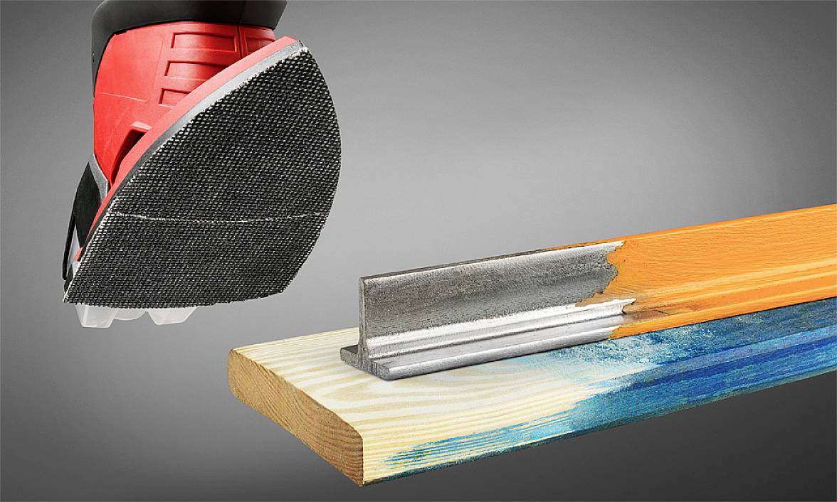 A piece of wood is being processed with a sanding machine. A red and black sander is removing paint from a wooden board.