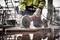 A worker is cutting tiles on a construction site using an electric cutting disc, whilst wearing protective clothing.