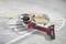 A red and black angle grinder lies on several white tile stacks on a grey surface.