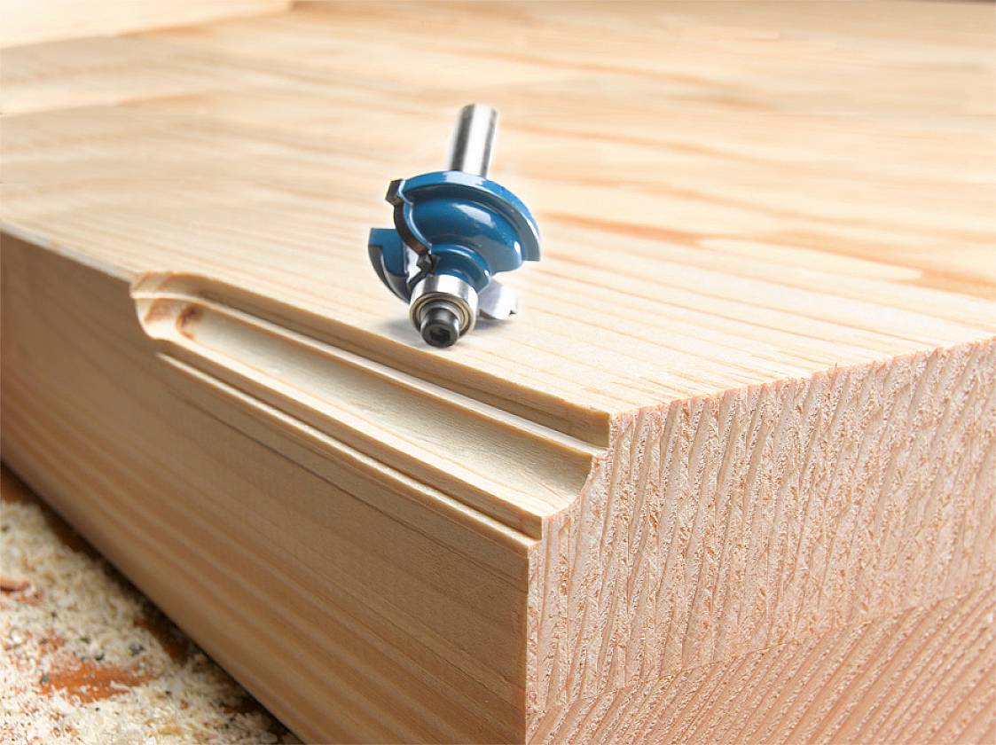 Router on wood with a milled groove, demonstrates precise woodworking technique. The main motif is the machining process on a light wooden surface.