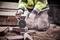 A person is cutting a brick with an angle grinder. They are wearing protective workwear and gloves.