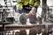 A worker in protective clothing cuts through a tile using an electric cutting disc on a construction site.
