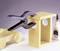 Wooden construction kit with an F-clamp holding two parts together. Next to it is a bottle of wood glue; a wooden toy car is lying to the left.