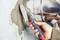 A hand is applying concrete to a wall with a trowel. A silver mixer is in the background.