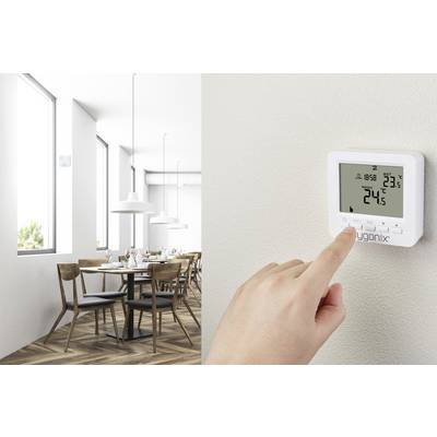 A person sets the temperature to 24.5 degrees Celsius on a wall thermostat in a modern dining room.