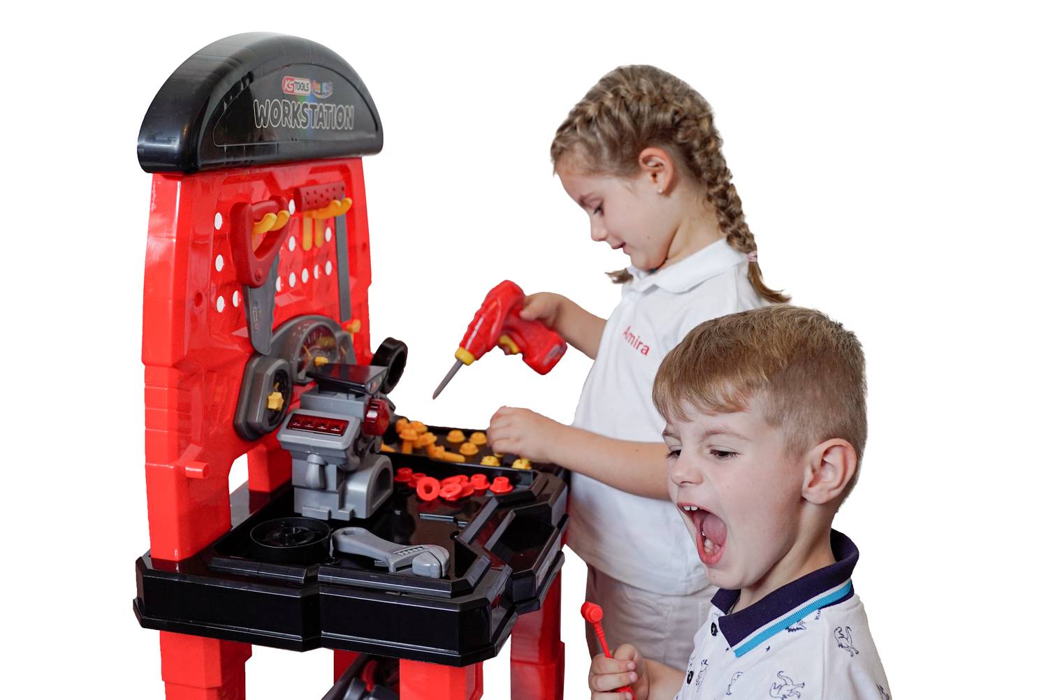 A girl and a boy are playing at a toy workbench. The girl is using a screwdriver, while the boy watches enthusiastically.