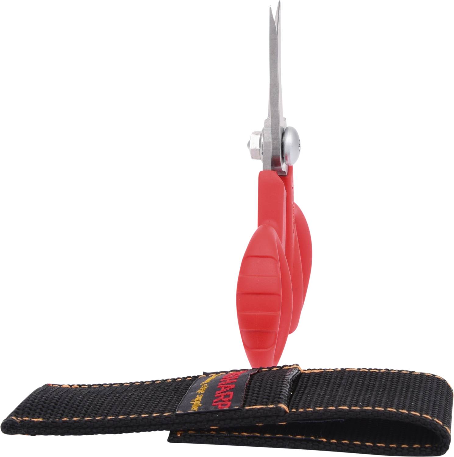 Red scissors with a sharp point viewed from the side, with a black protective cover laid beside them on a white background.