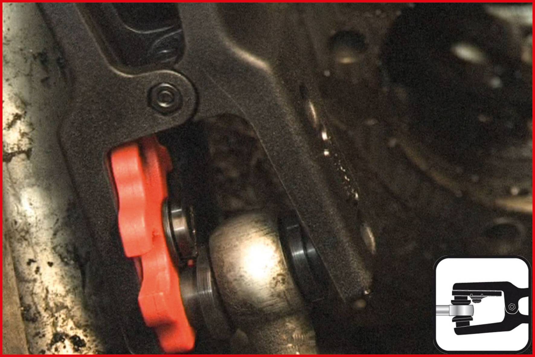 A close-up of a red and black brake calliper on a silver car component. A tool symbol is depicted bottom right.