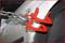 Red wheel clamp on a car tyre, prevents movement. Safety measure against unauthorised parking or theft.
