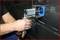 'Close-up of a person operating a machine on a metallic surface. The machine appears to be used for industrial work.'