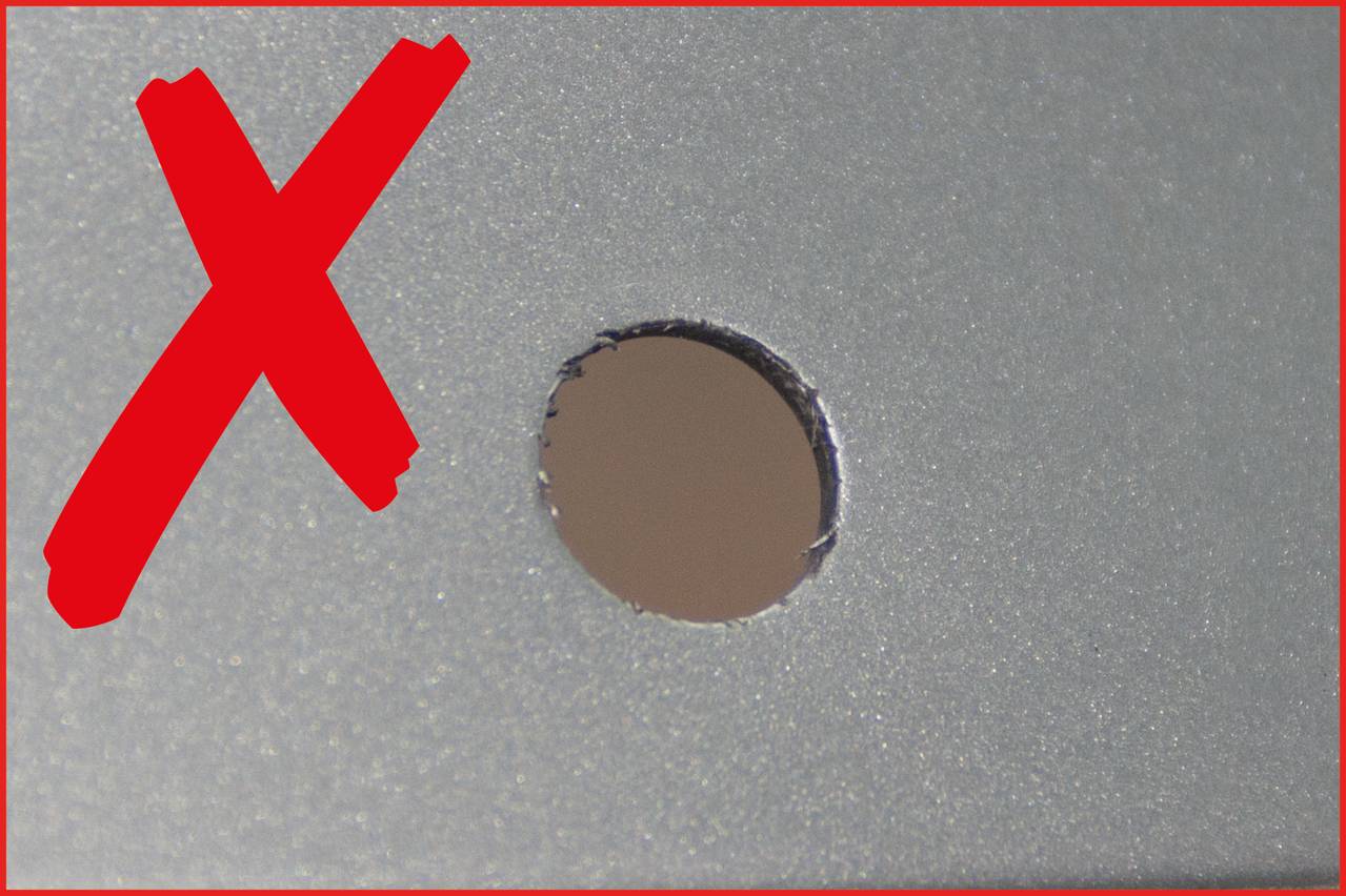 'X' in red next to a punched hole in a grey surface. Symbolises an error or unwanted action.