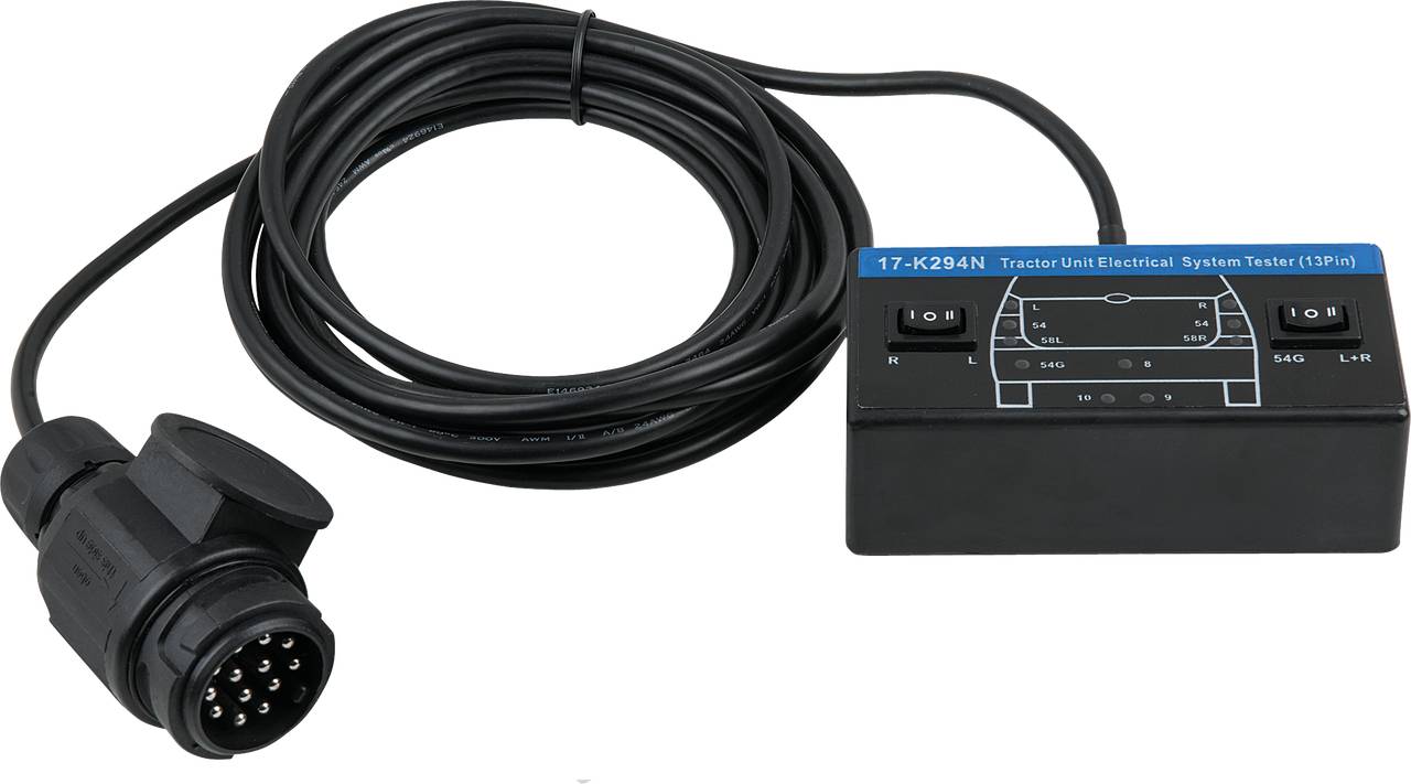 'Cable connected with plug connector to an electrical testing device for tractor units, showing switches and diagram on surface.'