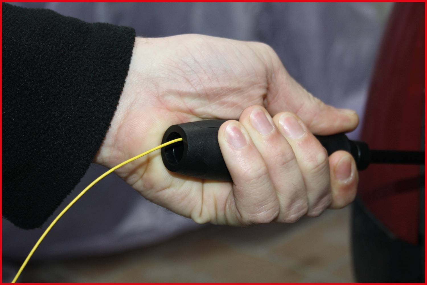 A hand is holding an electrical plug.