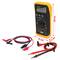 A digital multimeter with a yellow protective case, shown with test leads and crocodile clips, displaying measurements.
