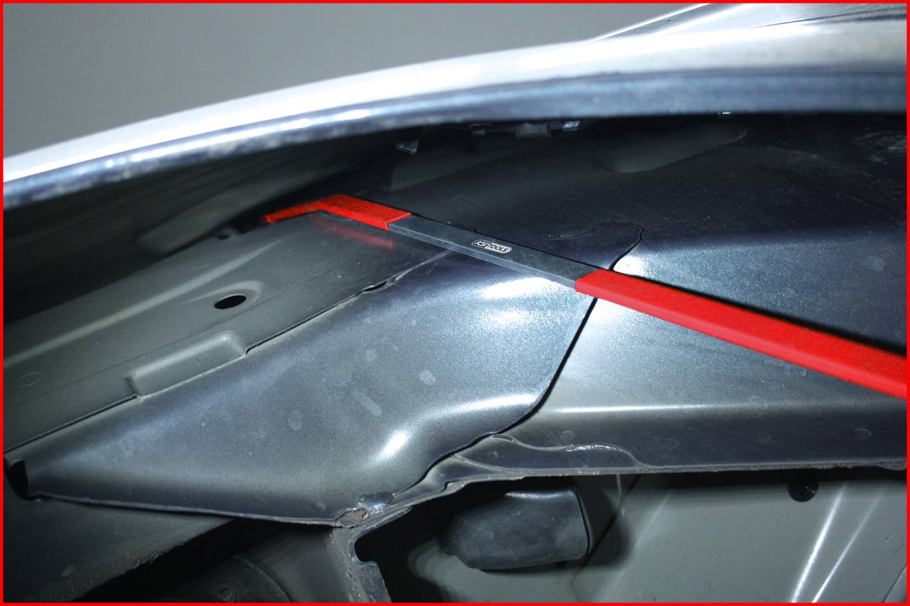 Metal bracket under a car's bonnet that secures a component.