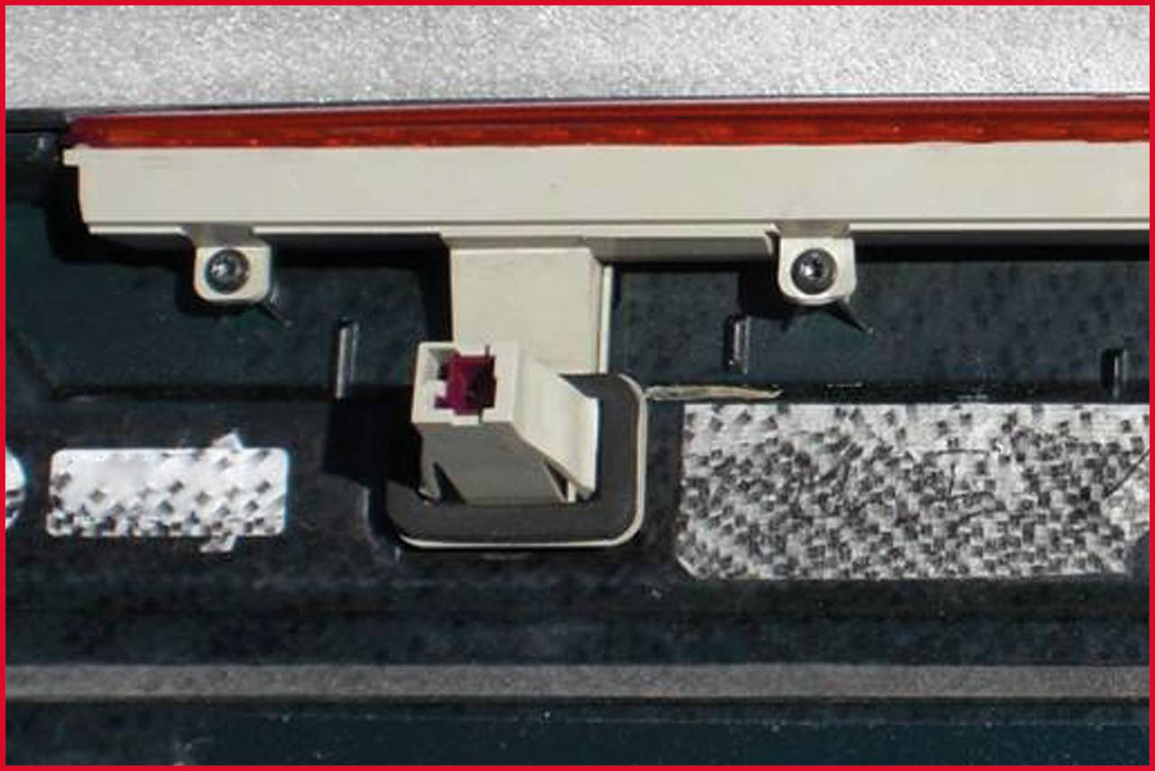 A connector on a circuit board can be seen. The main focus is on the central connection, which is plugged into the device.