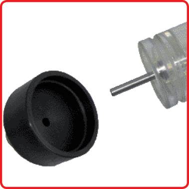 A plastic lid next to a syringe without a needle. The lid is positioned on the left, while the syringe extends into the image from the right.