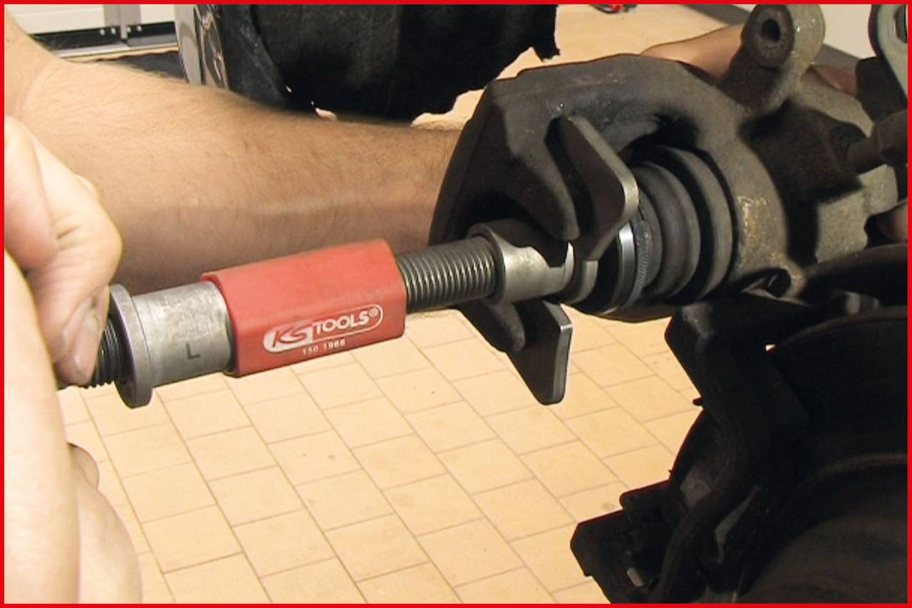 'A mechanic uses a KS Tools tool to repair an automotive component.'