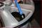 A tyre is being checked with a blue tool. The valve is visible. The main focus is on inspecting the wheel.