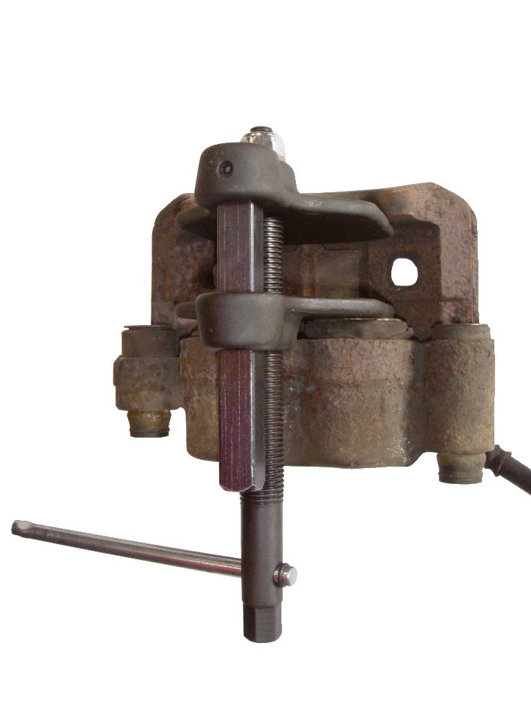 A brake calliper with a worn brown surface, secured by a puller tool used for maintenance or repair.