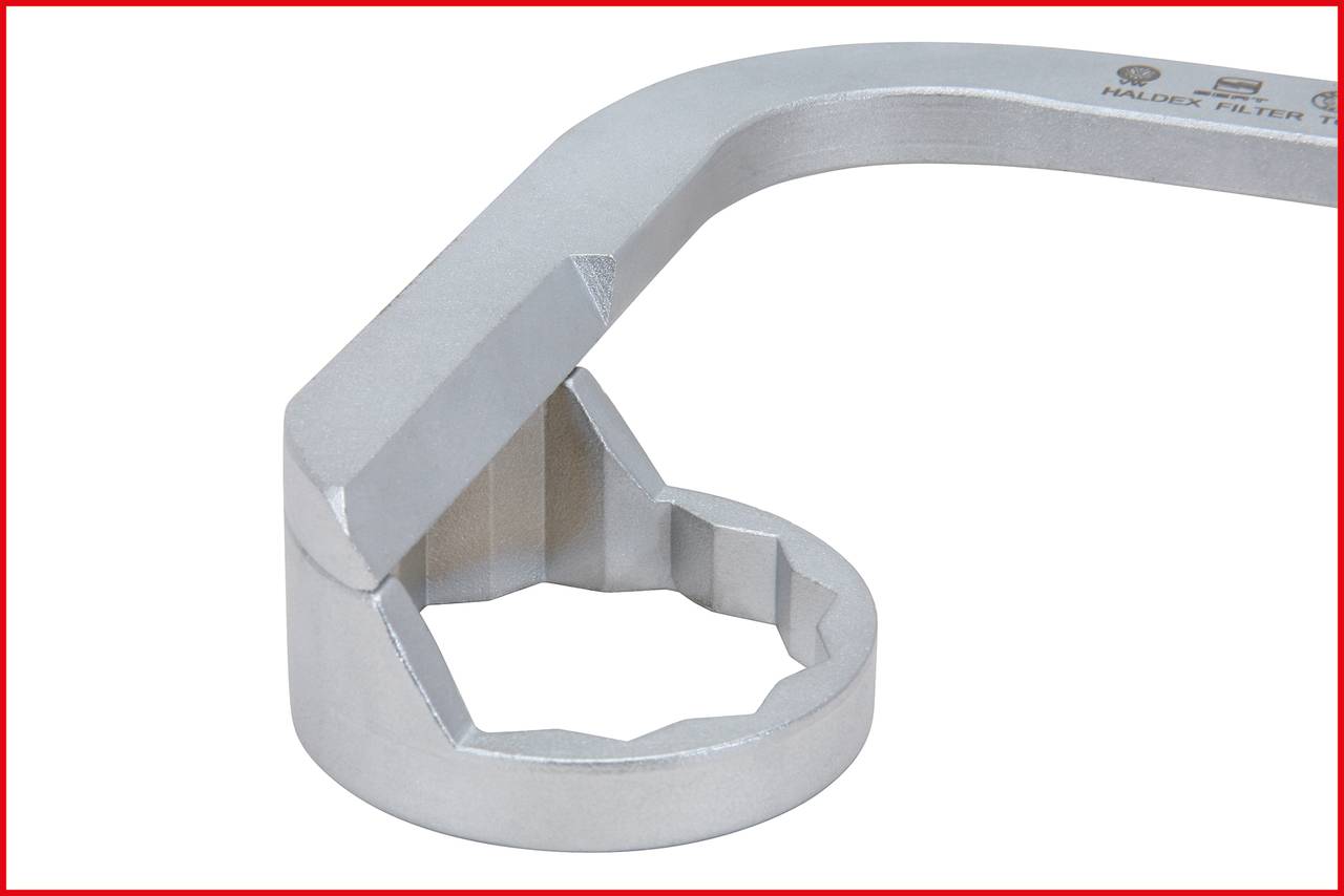 A silver spanner for specialised nuts with a uniquely shaped opening that is serrated and angular.