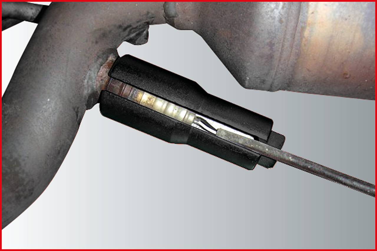 A black tool secures a metal rod to a curved pipe, likely part of a larger technical or mechanical system.