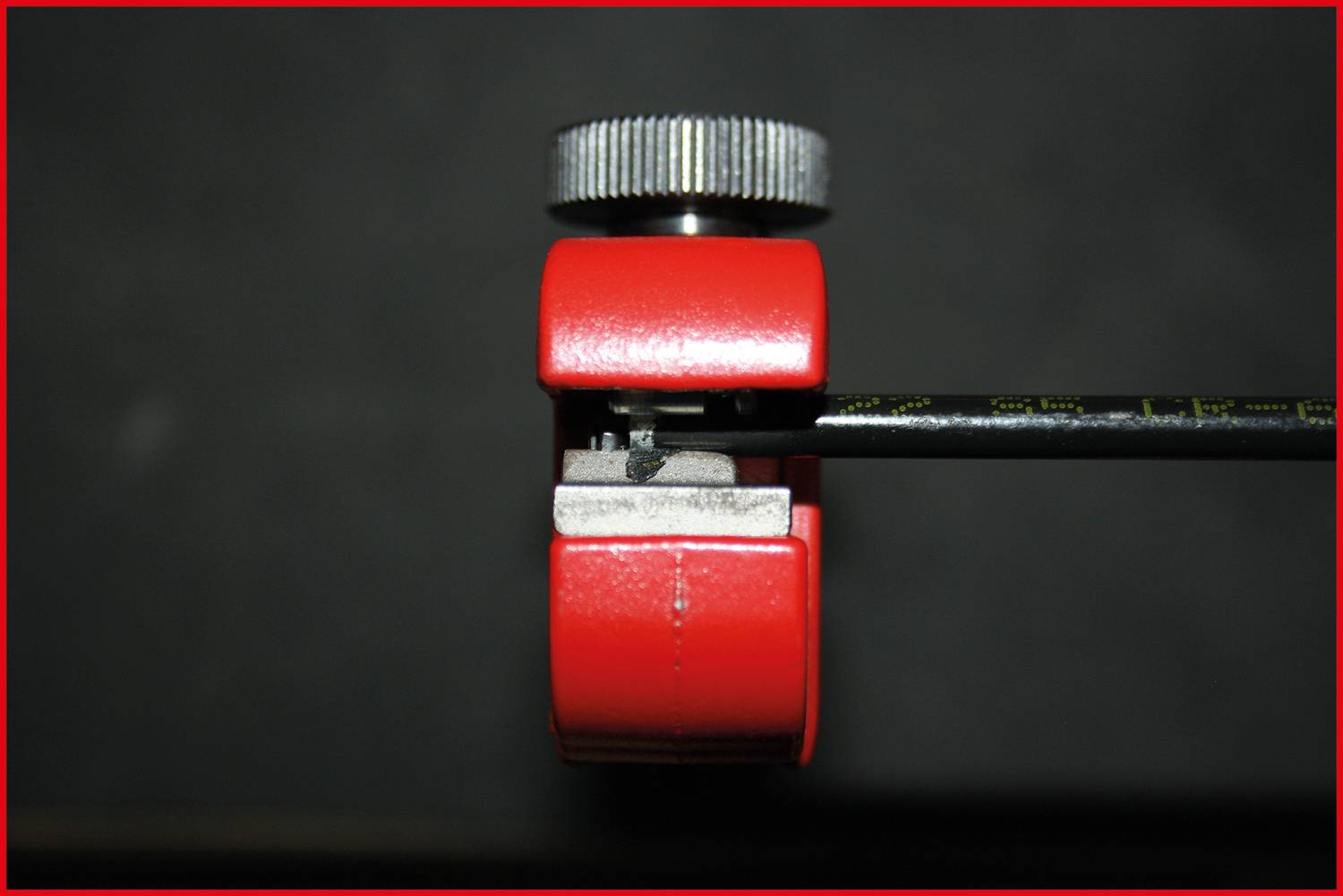 A tape measure is clamped with a red measuring tool to enable a precise measurement.