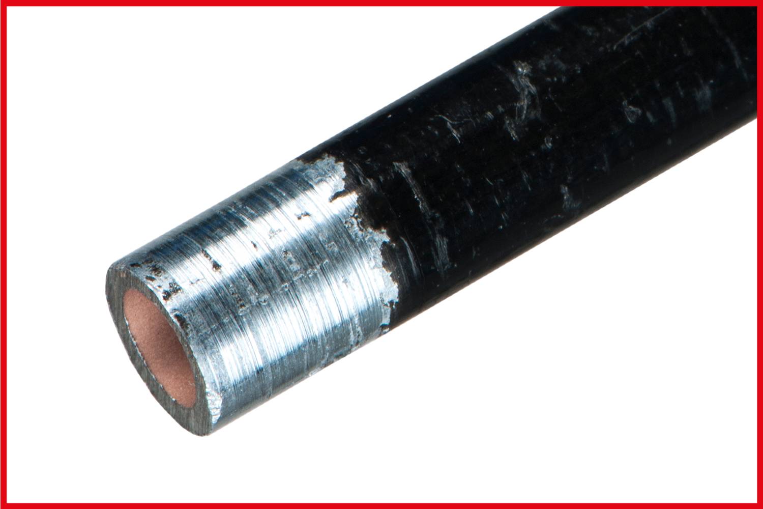 Close-up of a metal pipe with a bevelled, silver-gleaming end and dark coating.