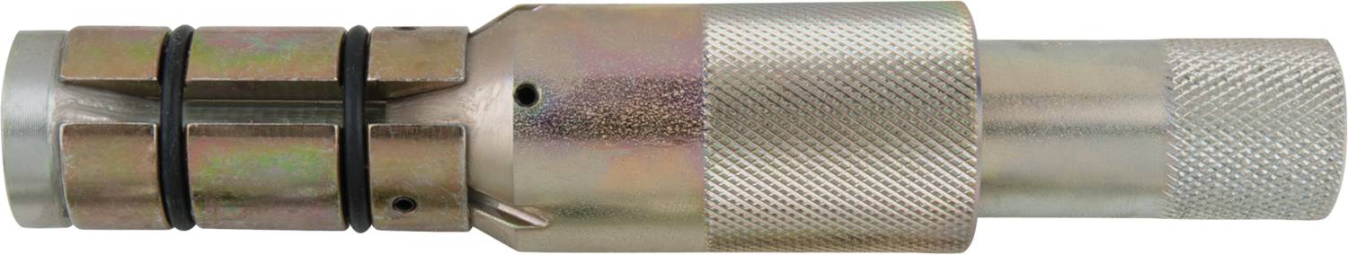 In the image, a silver, metallic tool with a ribbed surface and multiple connection points can be seen.