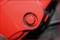 A red screw is tightly fixed in a red, metallic component. The surface is smooth and slightly glossy.