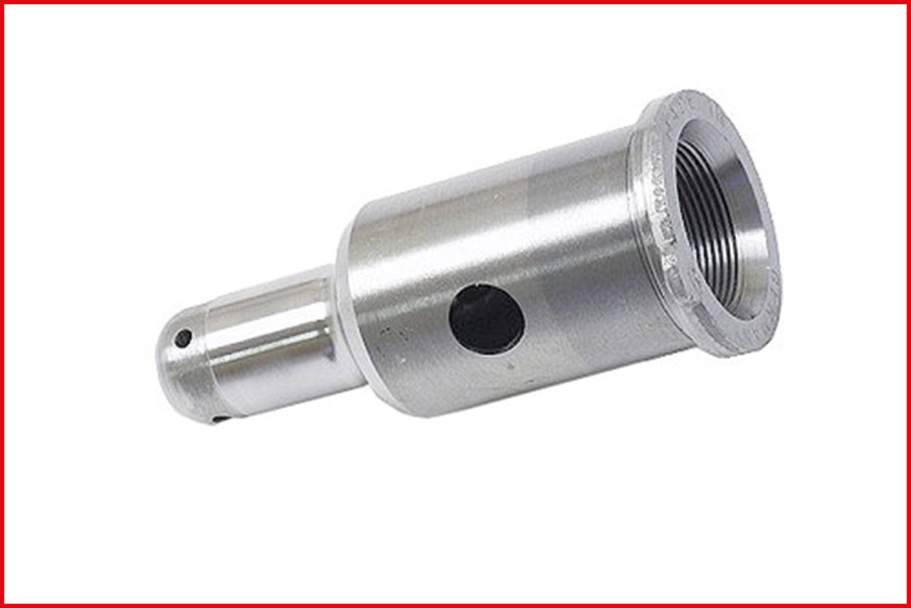 A metallic cylinder with multiple holes, presumably a machine part or adapter, lies against a white background.