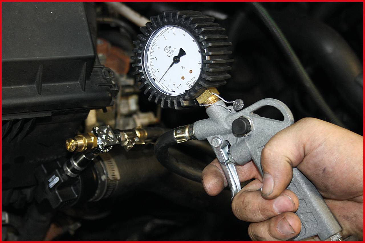 'Hand holding an air pressure gun with pressure gauge'